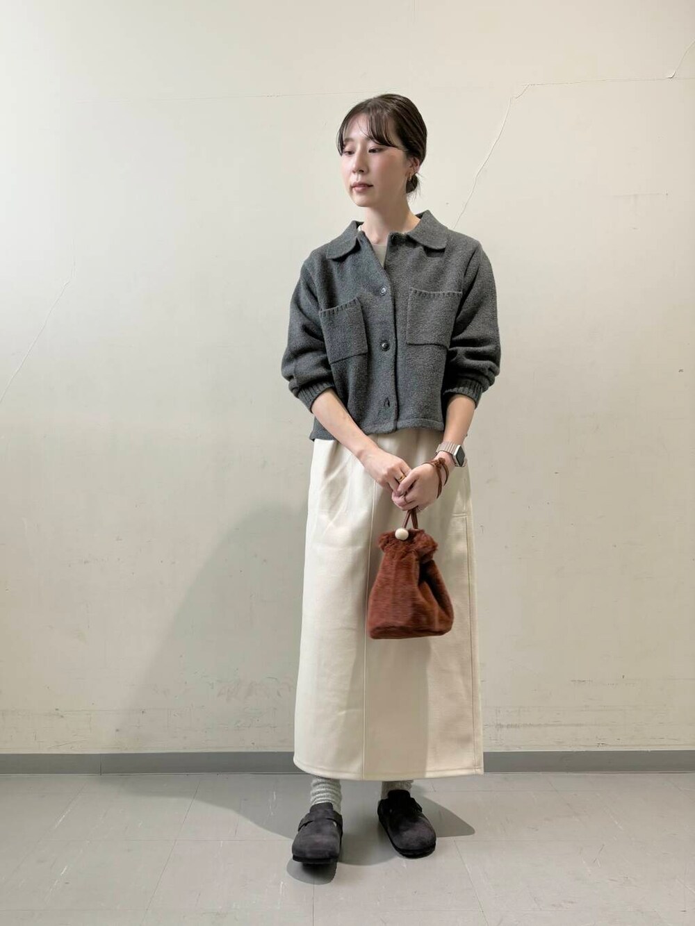 ホワイト系のスカート、ブラウン系のショルダーバッグ、グレー系のサンダルを着用したレディースの秋コーディネートの3枚目の写真