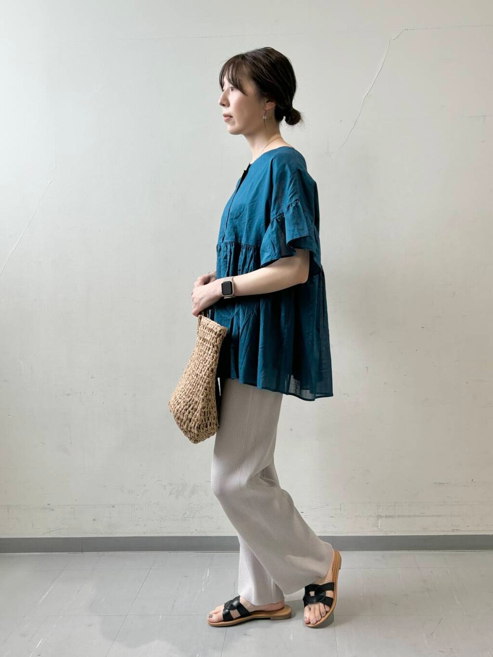 グレー系のその他パンツ、ブラック系のサンダル、ベージュ系のトートバッグを着用したレディースの夏コーディネートの2枚目の写真