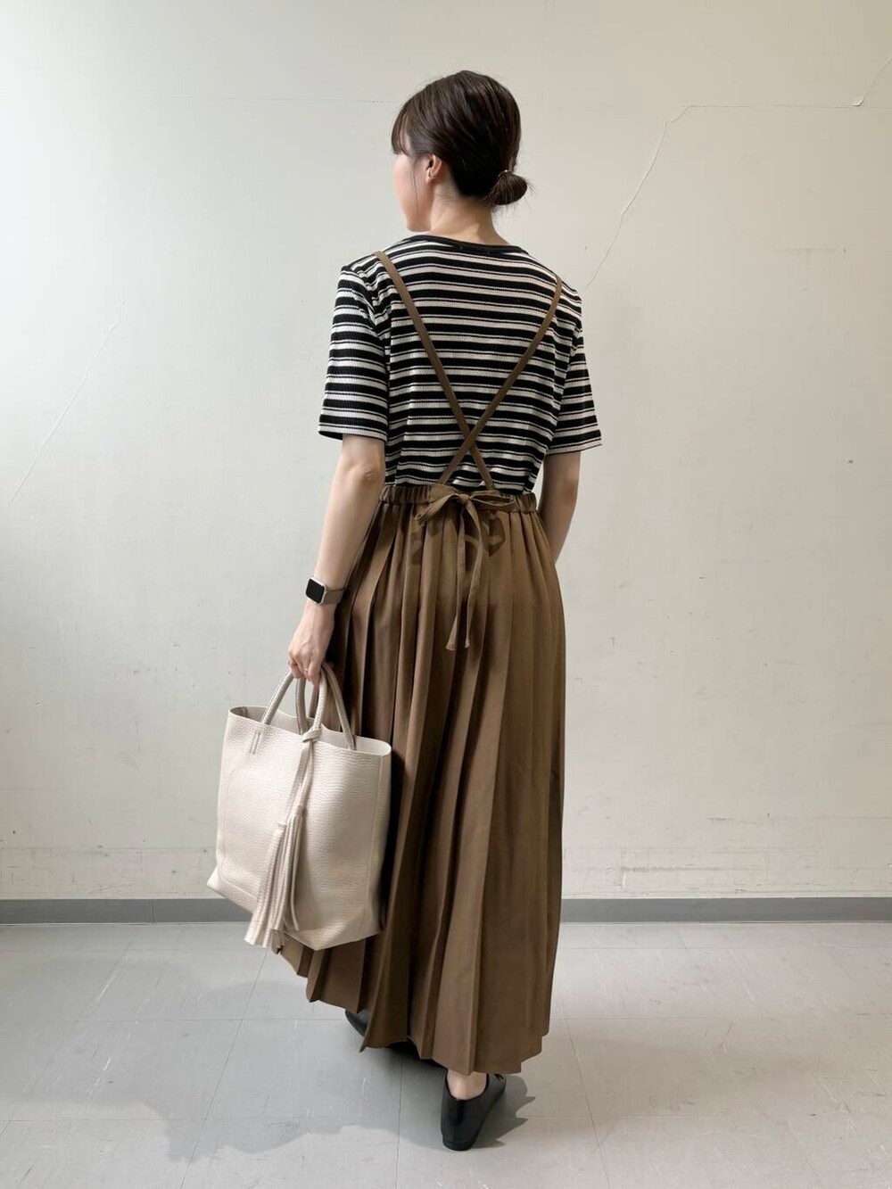 ホワイト系のトートバッグ、ブラック系のTシャツ/カットソー、イエロー系のスカートを着用したレディースの夏コーディネートの4枚目の写真