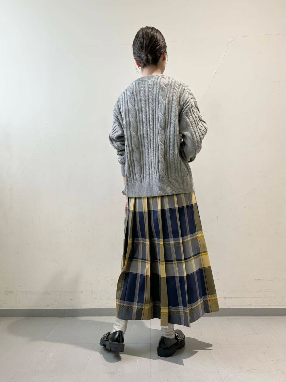 グレー系のカーディガン/ボレロ、グレー系のショルダーバッグ、ブルー系のスカートを着用したレディースの秋コーディネートの6枚目の写真