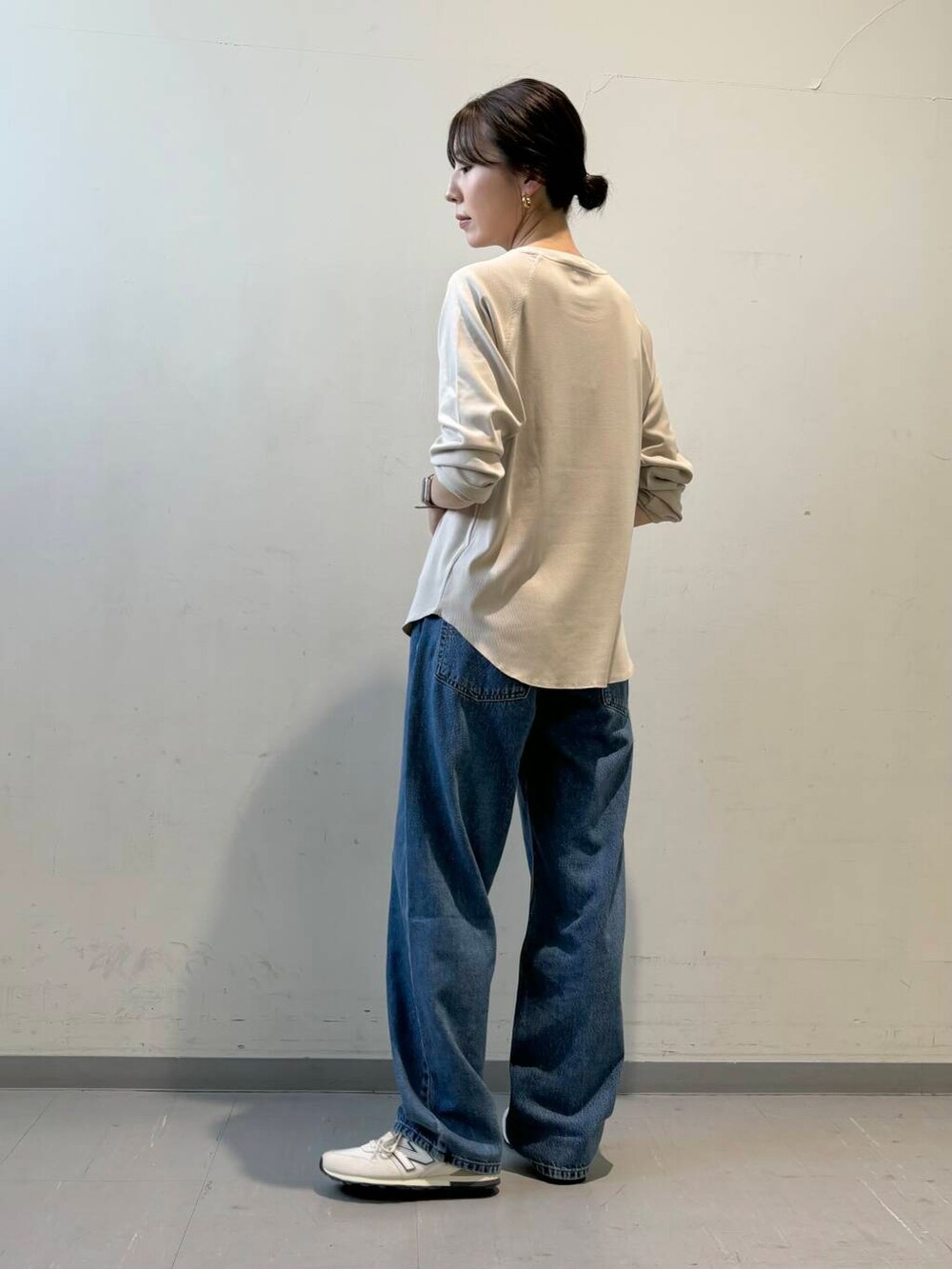 ブルー系のデニムパンツ、ホワイト系のスニーカー、イエロー系のカーディガン/ボレロを着用したレディースの秋コーディネートの5枚目の写真