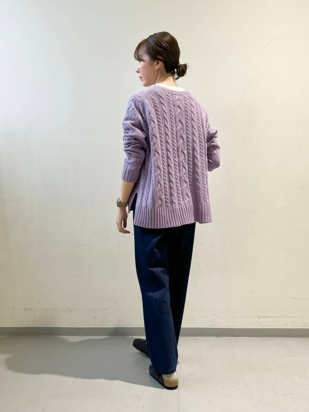 ブルー系のデニムパンツ、パープル系のニット/セーター、ホワイト系のダウンジャケット/コートを着用したレディースの秋コーディネートの6枚目の写真