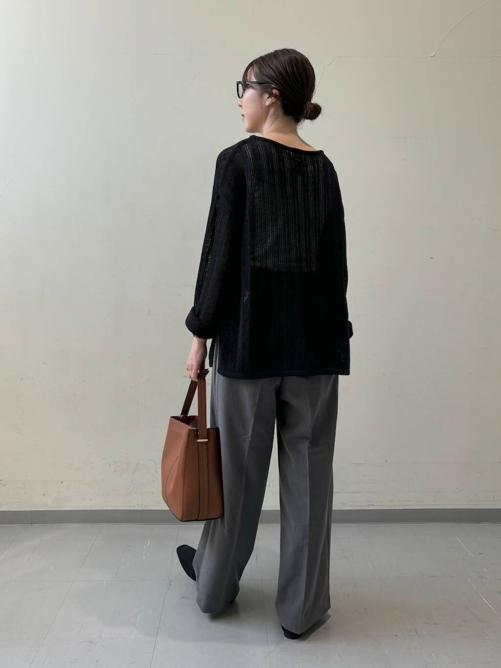 ブラウン系のハンドバッグ、グレー系のその他パンツ、ブラック系のニット/セーターを着用したレディースの夏コーディネートの4枚目の写真