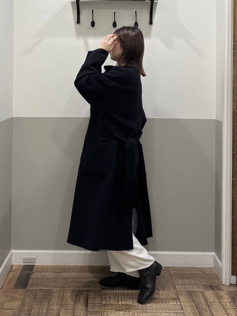 ブルー系のステンカラーコート、ピンク系のニット/セーター、ブラック系のブーツを着用したレディースの秋コーディネートの3枚目の写真