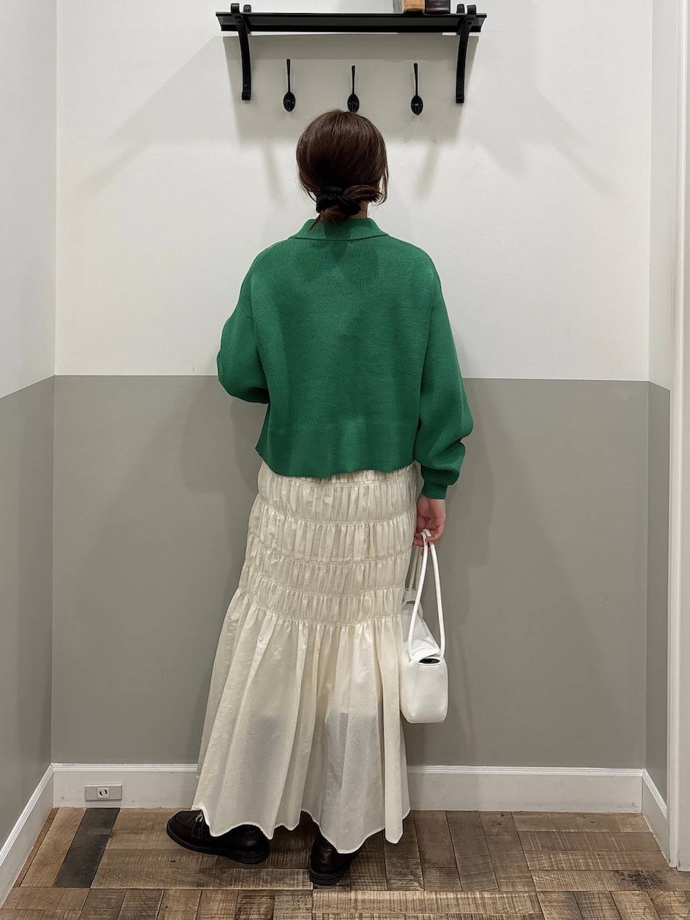 ブラウン系のローファー、ホワイト系のショルダーバッグ、グリーン系のカーディガン/ボレロを着用したレディースの冬コーディネートの4枚目の写真