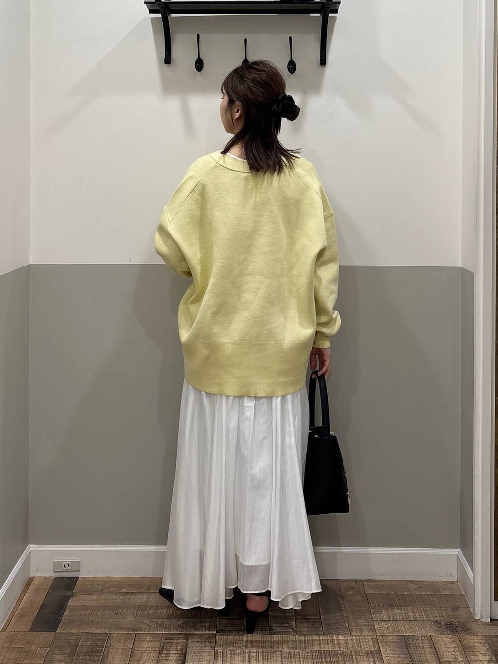 イエロー系のカーディガン/ボレロ、ホワイト系のスカート、ブラック系のその他シューズを着用したレディースの冬コーディネートの4枚目の写真