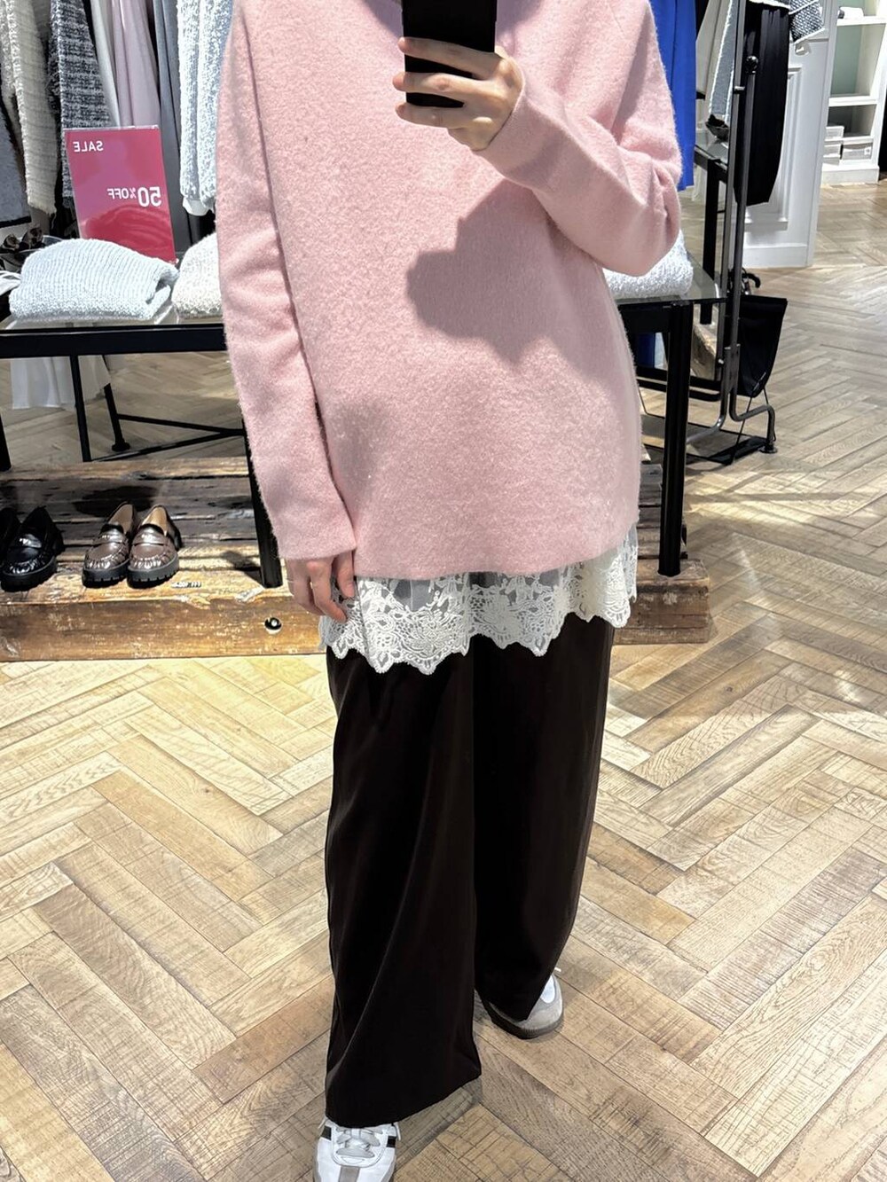 ピンク系のニット/セーター、ブラウン系のスラックス、ホワイト系のチュニックを着用したレディースの冬コーディネートの2枚目の写真