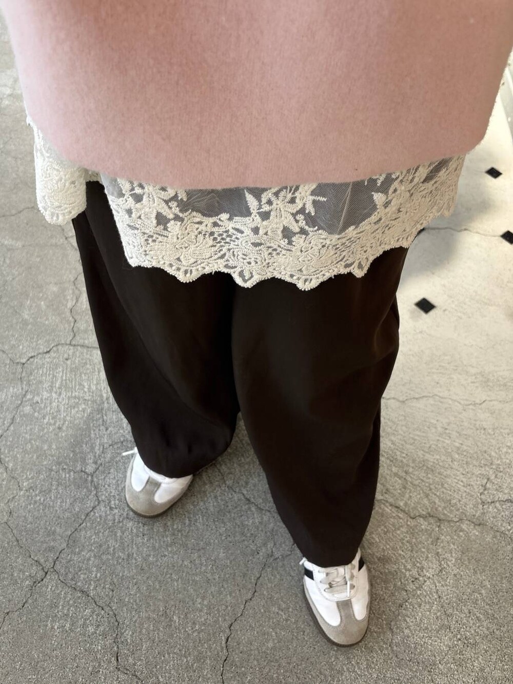 ピンク系のニット/セーター、ブラウン系のスラックス、ホワイト系のチュニックを着用したレディースの冬コーディネートの4枚目の写真