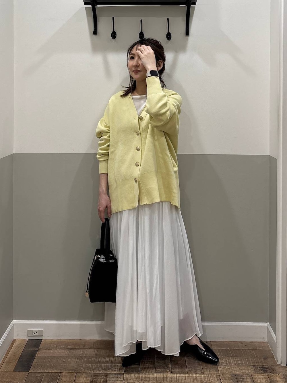 イエロー系のカーディガン/ボレロ、ホワイト系のスカート、ブラック系のその他シューズを着用したレディースの冬コーディネートの3枚目の写真