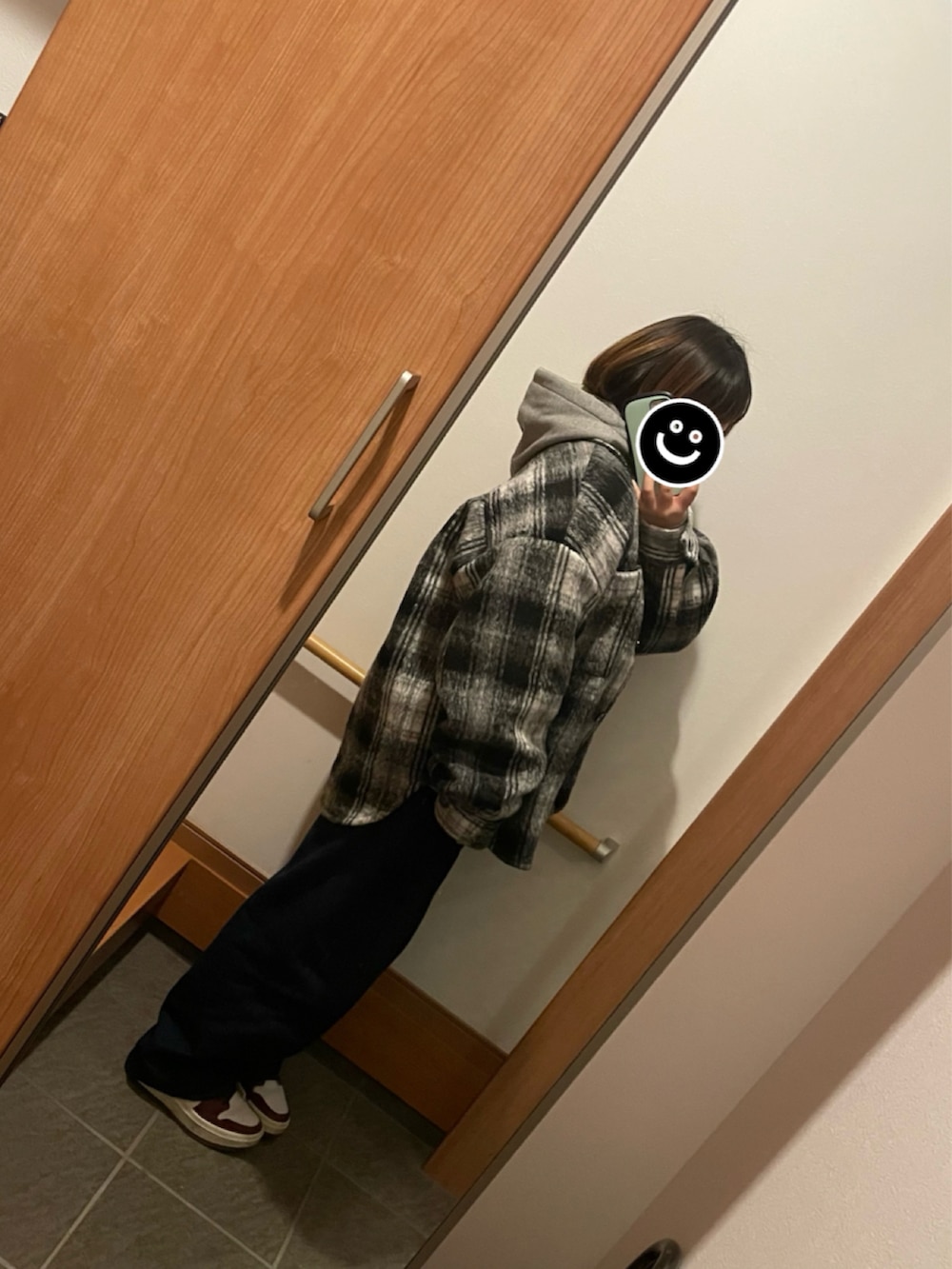 ブラック系のブルゾン、グレー系のパーカー、ブルー系のデニムパンツを着用したレディースの冬コーディネートの2枚目の写真