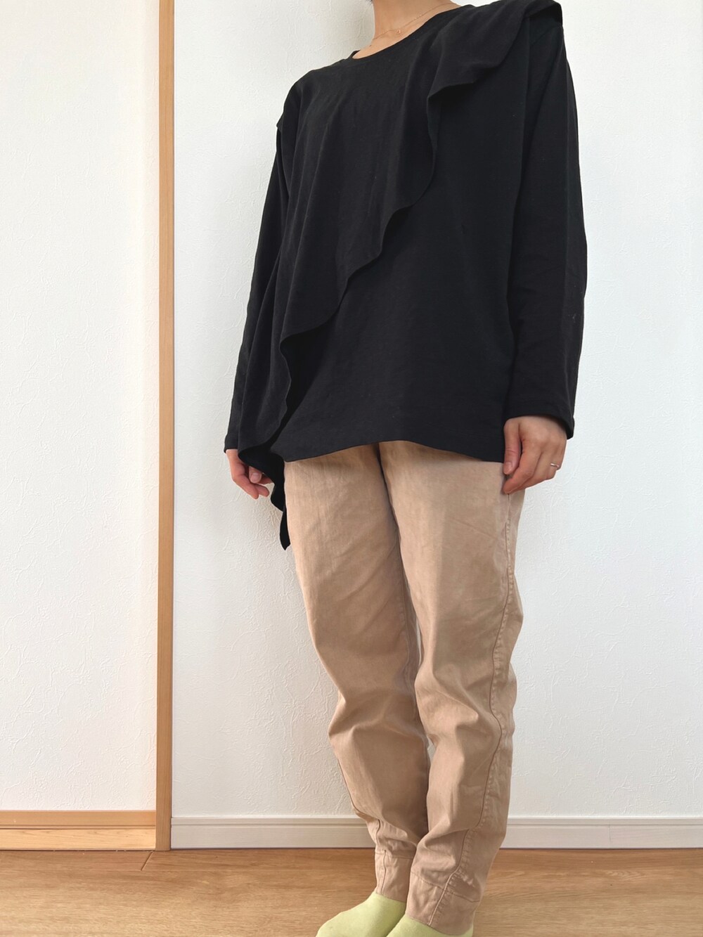 ブラック系のTシャツ/カットソー、ベージュ系のパンツを着用したレディースの春コーディネートの2枚目の写真