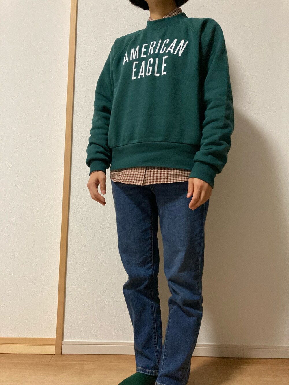 ブルー系のデニムパンツ、ブラウン系のシャツ/ブラウス、グリーン系のスウェットを着用したレディースの秋コーディネートの2枚目の写真