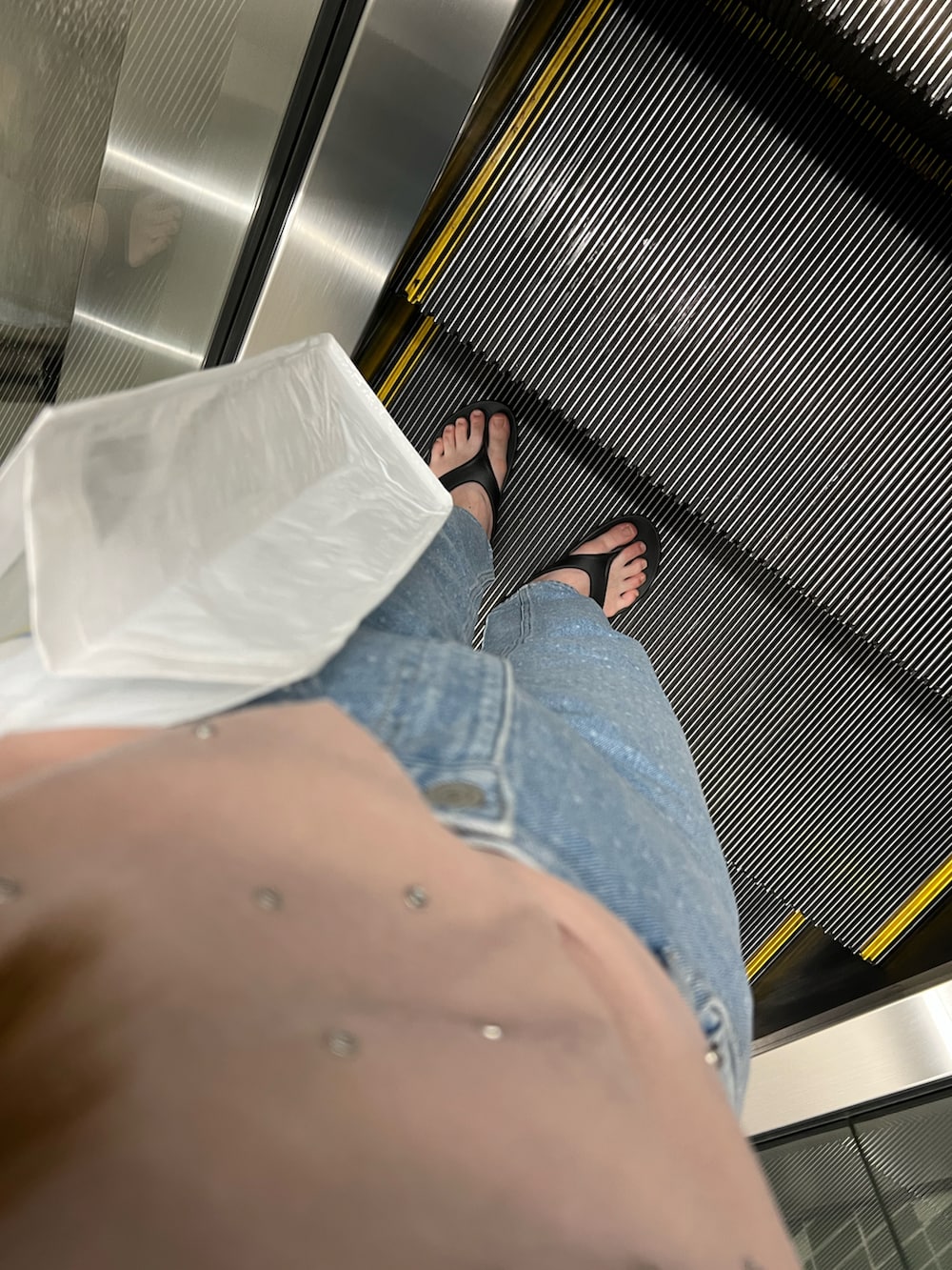 ブルー系のデニムパンツ、ピンク系のTシャツ/カットソー、ブラック系のサンダルを着用したレディースの春コーディネートの2枚目の写真