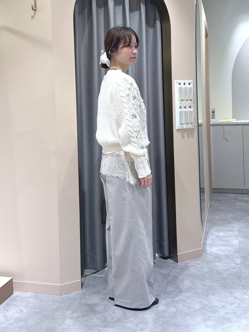 ブラウン系のハンドバッグ、ブラウン系のブーツ、ベージュ系のスラックスを着用したレディースの冬コーディネートの2枚目の写真