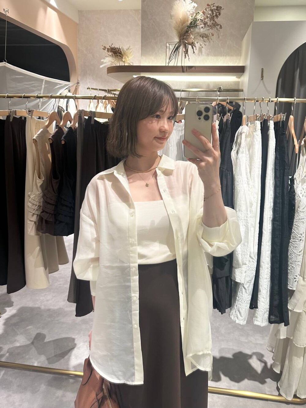 ブラウン系のボストンバッグ、ホワイト系のキャミソール、ホワイト系のシャツ/ブラウスを着用したレディースの秋コーディネートの2枚目の写真