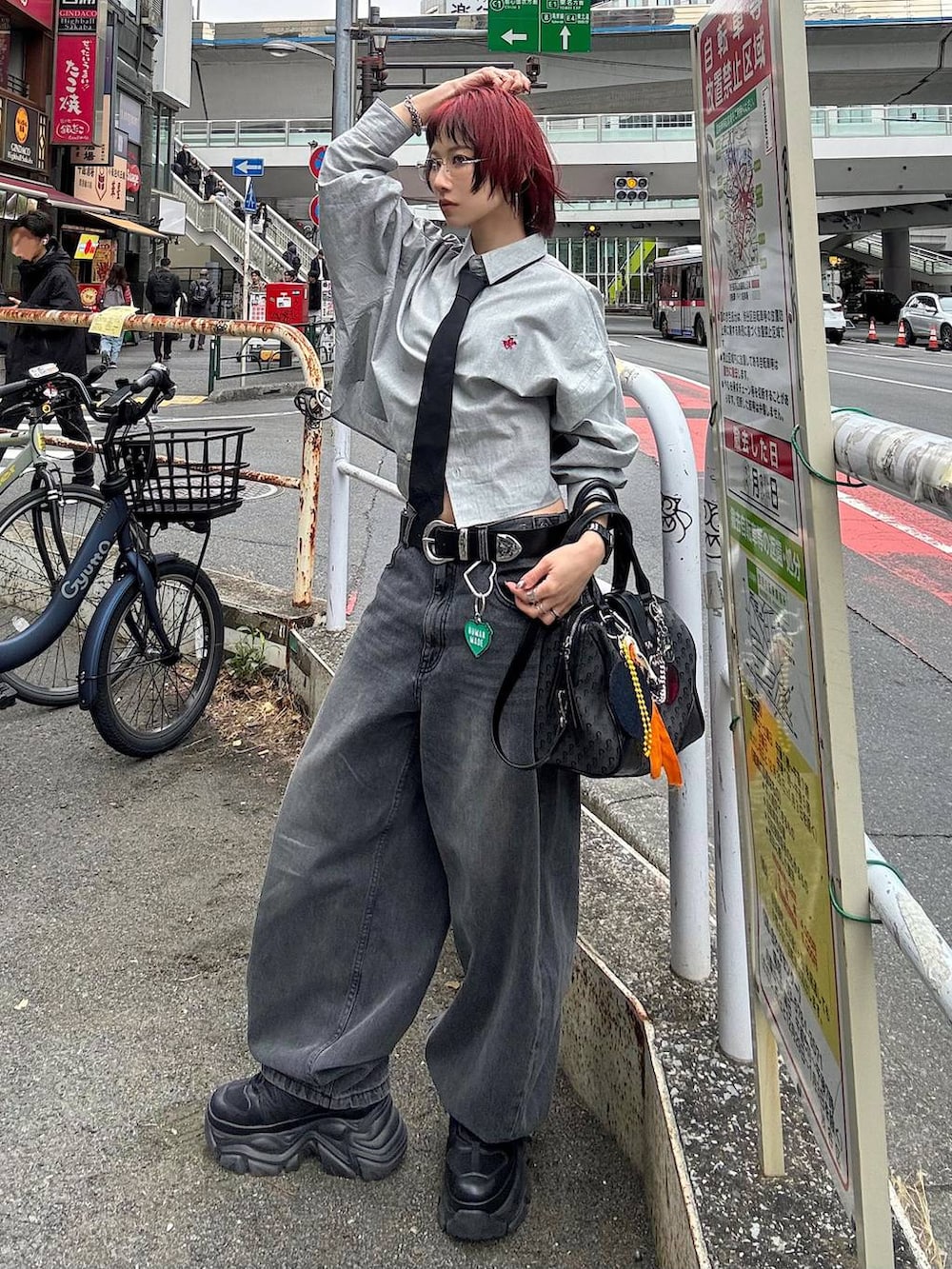 ブラック系のスニーカー、ブラック系のボストンバッグ、ブラック系のデニムパンツを着用したレディースの春コーディネートの2枚目の写真