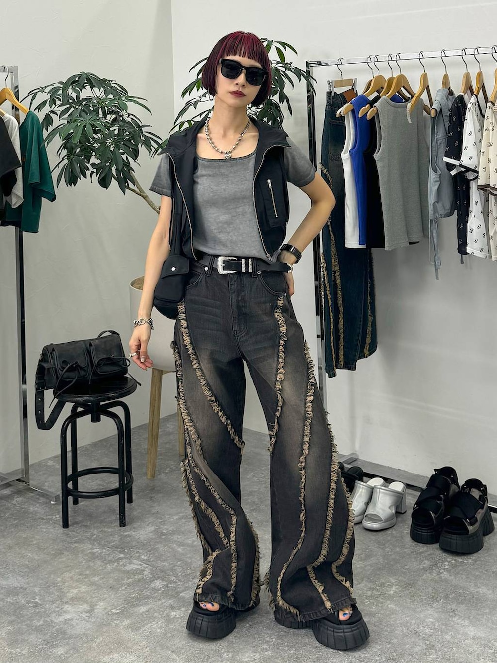 ブラック系のスニーカー、ブラック系のショルダーバッグ、グレー系のTシャツ/カットソーを着用したレディースの夏コーディネートの2枚目の写真