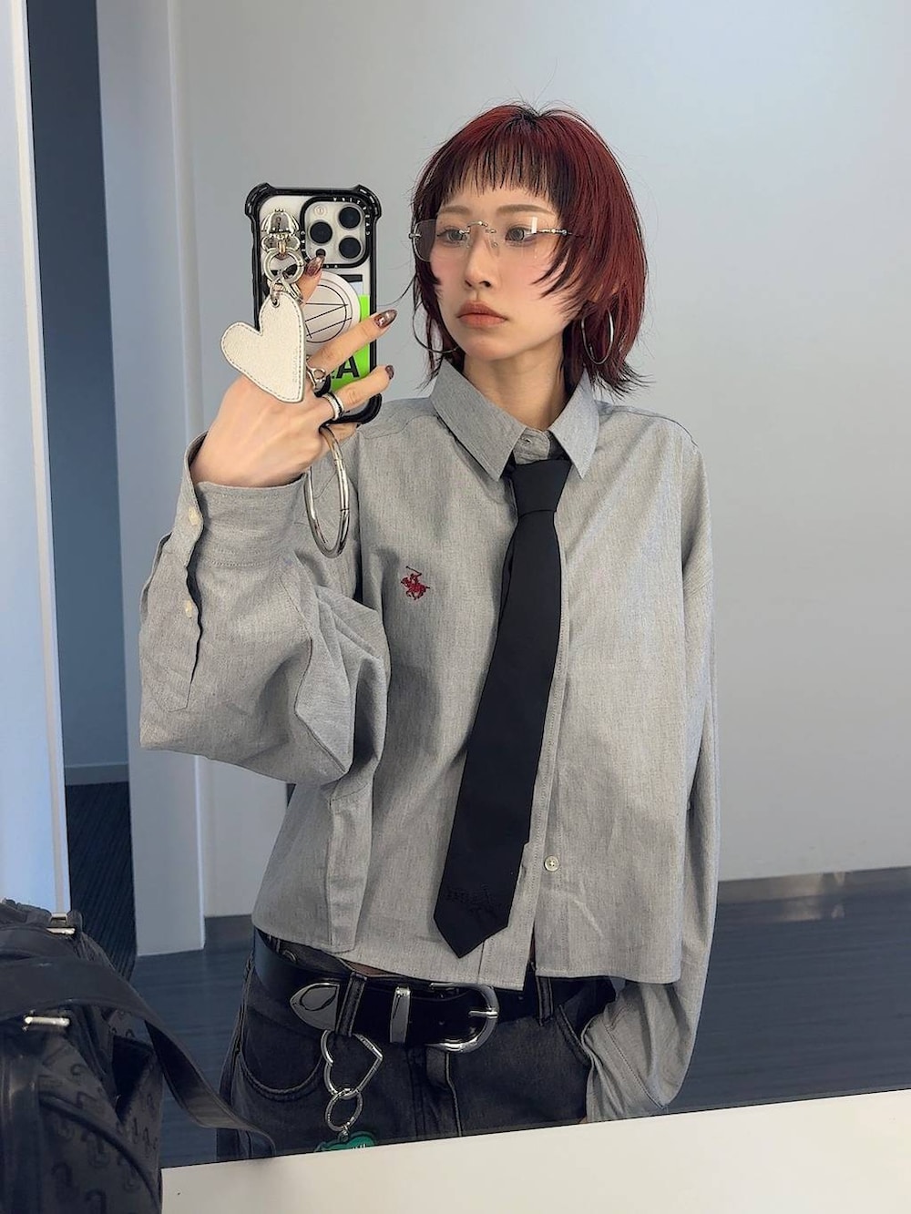 ブラック系のスニーカー、ブラック系のボストンバッグ、ブラック系のデニムパンツを着用したレディースの春コーディネートの4枚目の写真