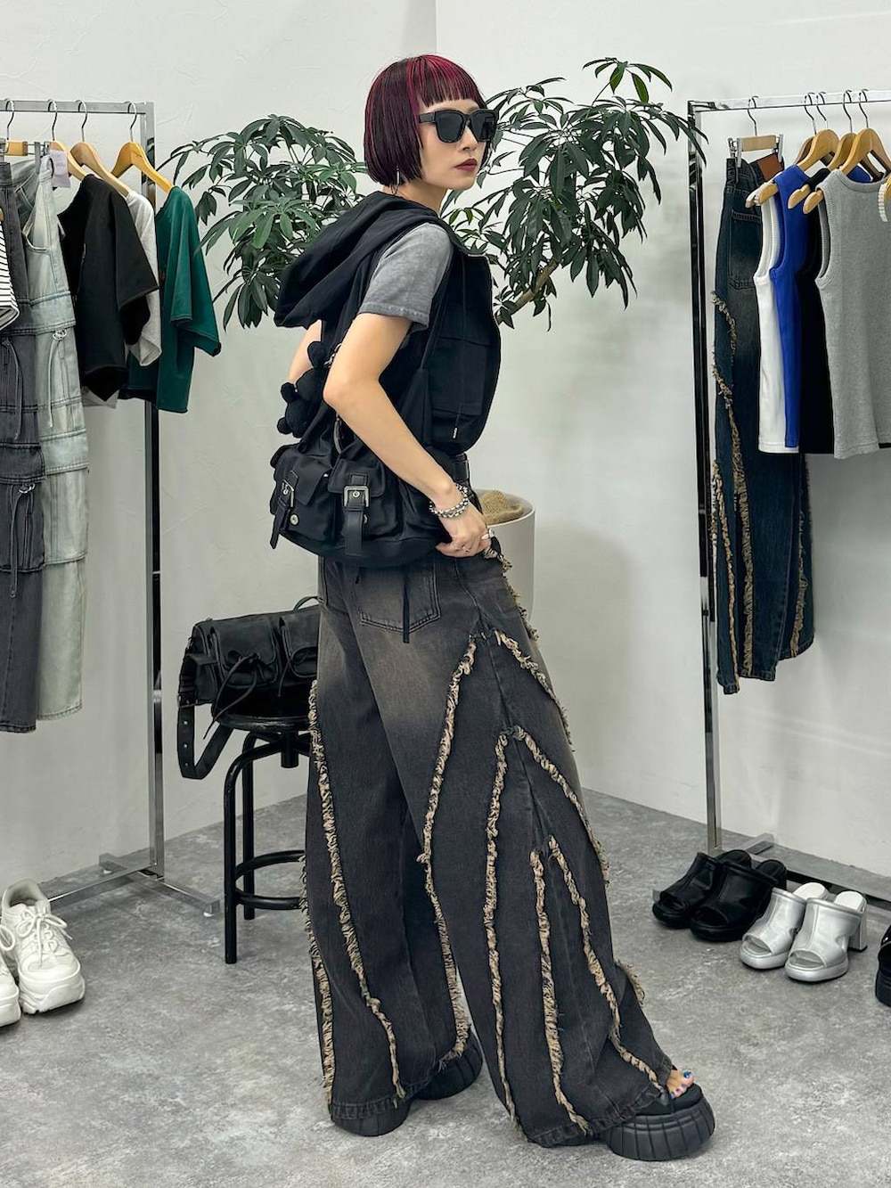 ブラック系のスニーカー、ブラック系のショルダーバッグ、グレー系のTシャツ/カットソーを着用したレディースの夏コーディネートの6枚目の写真