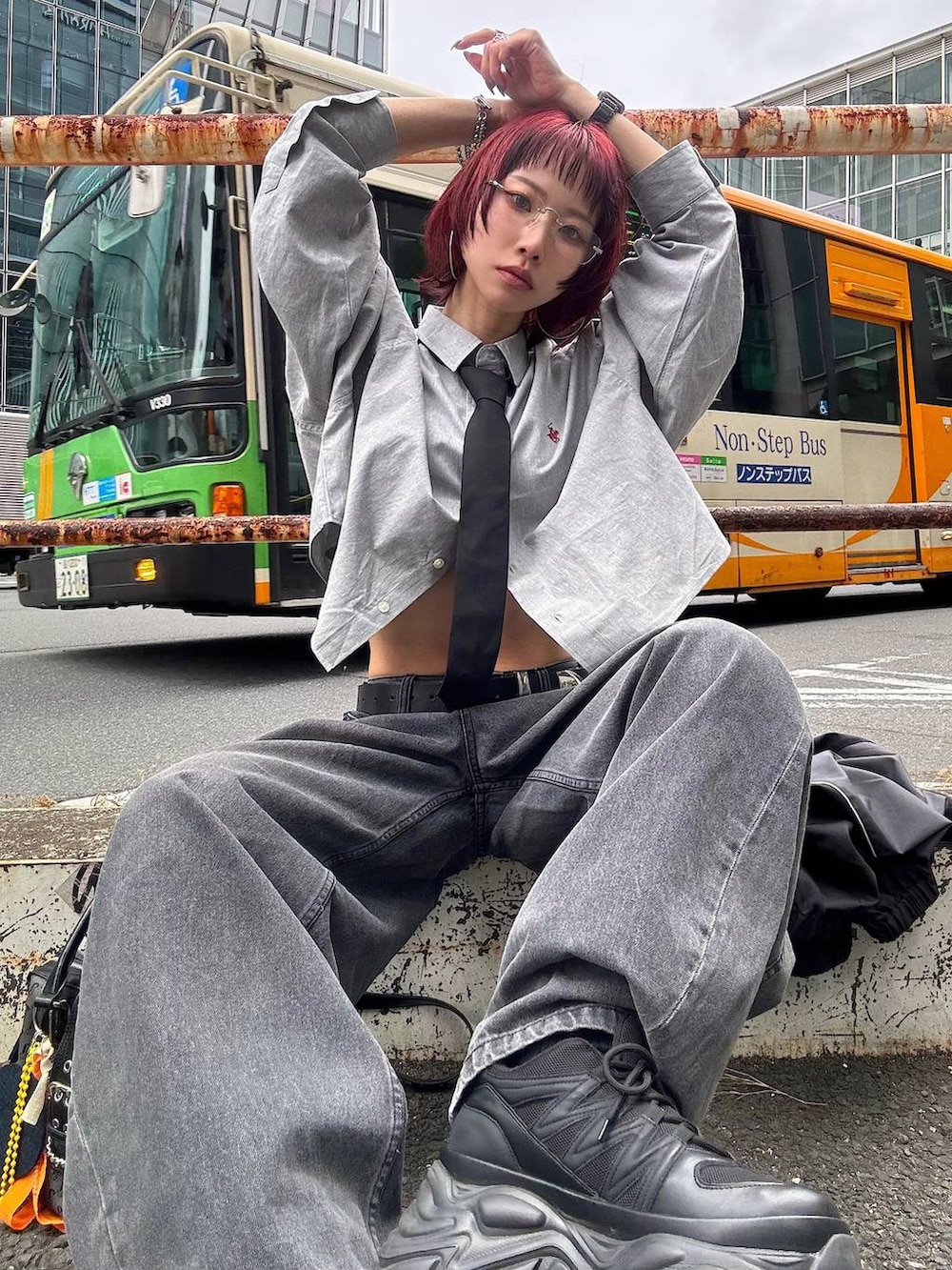 ブラック系のスニーカー、ブラック系のボストンバッグ、ブラック系のデニムパンツを着用したレディースの春コーディネートの3枚目の写真