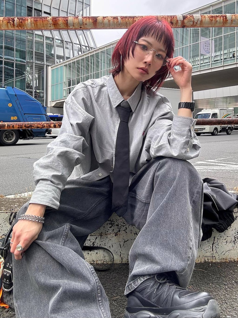 ブラック系のスニーカー、ブラック系のボストンバッグ、ブラック系のデニムパンツを着用したレディースの春コーディネートの6枚目の写真