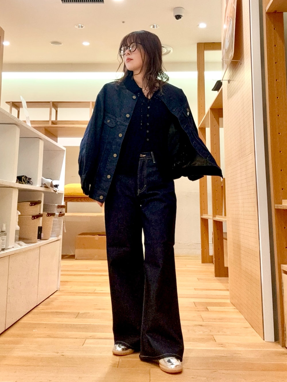 ブラック系のニット/セーター、ブルー系のデニムジャケット、ブルー系のデニムパンツを着用したレディースの冬コーディネートの2枚目の写真