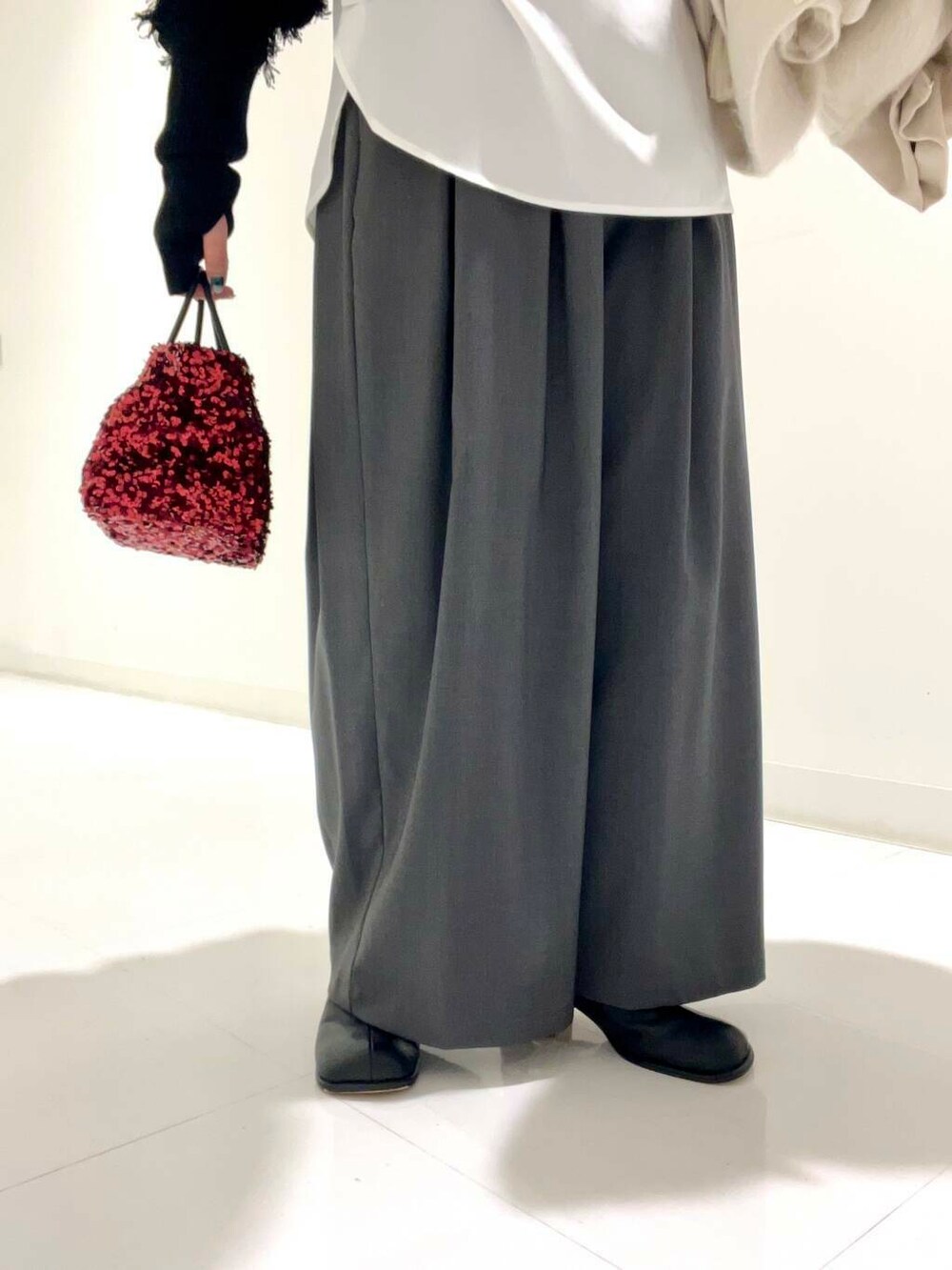 グレー系のその他パンツ、ホワイト系のシャツ/ブラウス、レッド系のショルダーバッグを着用したレディースの冬コーディネートの7枚目の写真