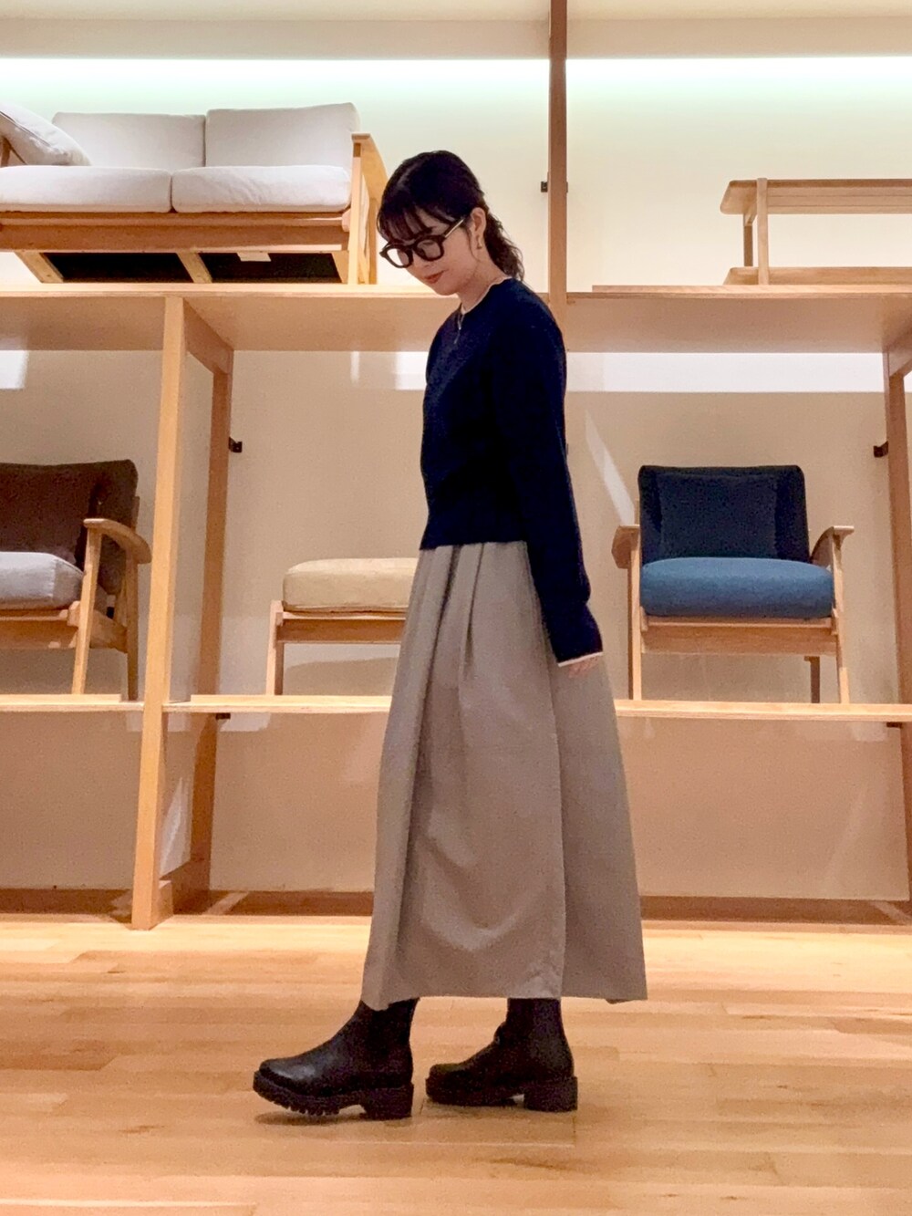 ブラック系のピーコート、ブラック系のハンドバッグ、ブルー系のニット/セーターを着用したレディースの冬コーディネートの6枚目の写真