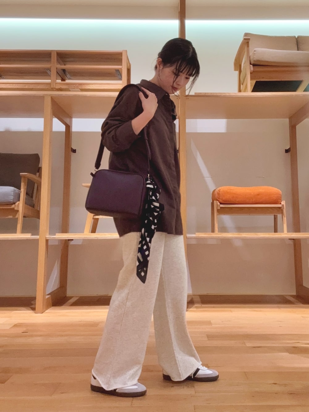 レッド系のショルダーバッグ、ブラウン系のシャツ/ブラウス、ブラック系のバンダナ/スカーフを着用したレディースの秋コーディネートの2枚目の写真