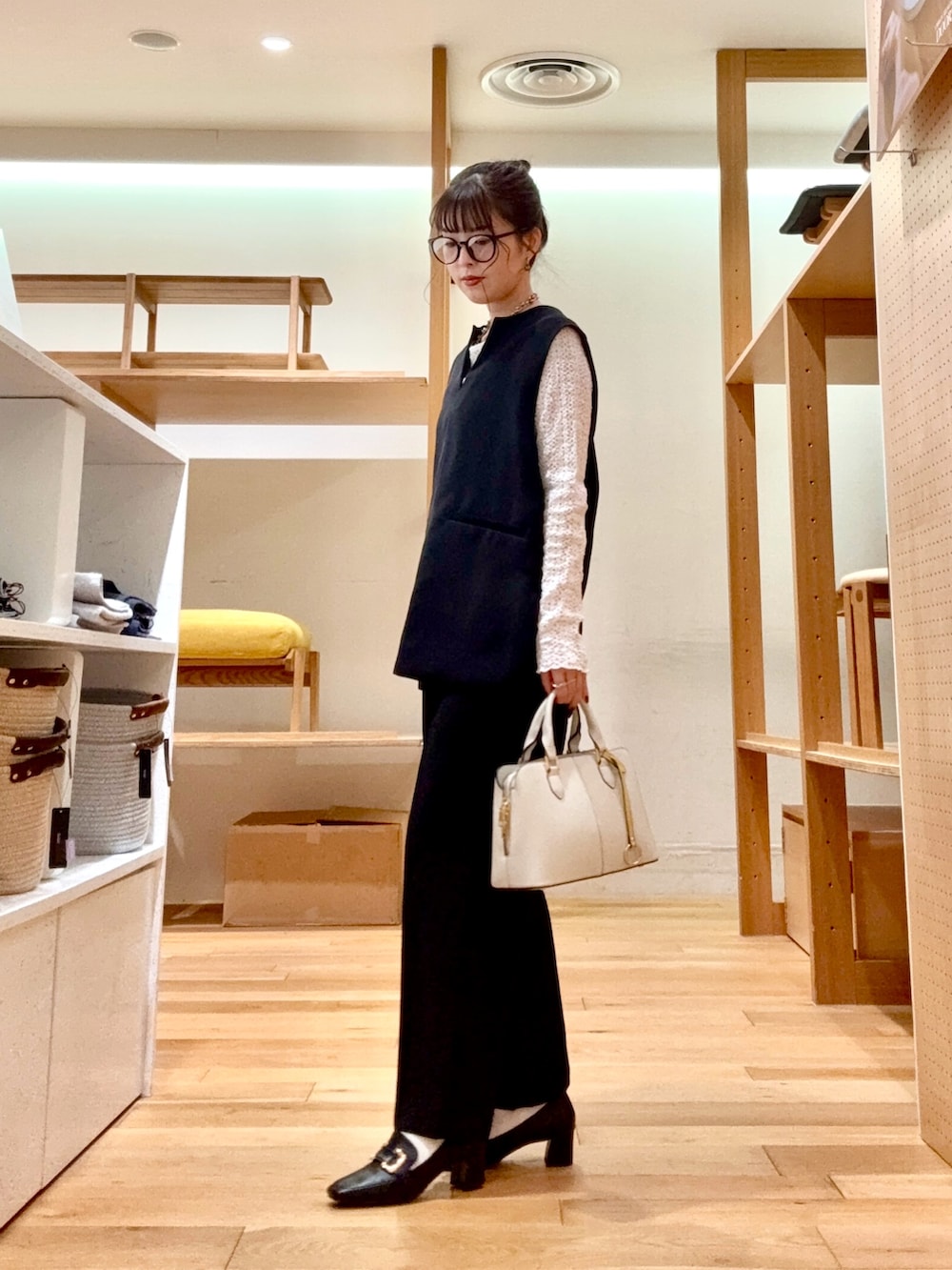 ホワイト系のTシャツ/カットソー、ブラック系のベスト、ブラック系のその他パンツを着用したレディースの冬コーディネートの2枚目の写真