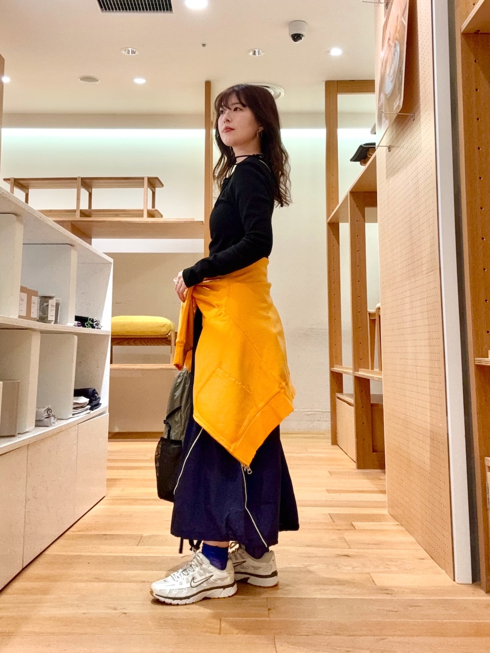 ホワイト系のスニーカー、グレー系のバックパック/リュック、ブルー系のスカートを着用したレディースの春コーディネートの5枚目の写真