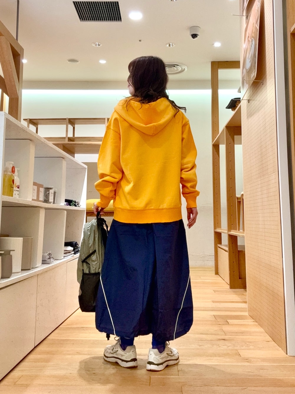 ホワイト系のスニーカー、グレー系のバックパック/リュック、ブルー系のスカートを着用したレディースの春コーディネートの3枚目の写真