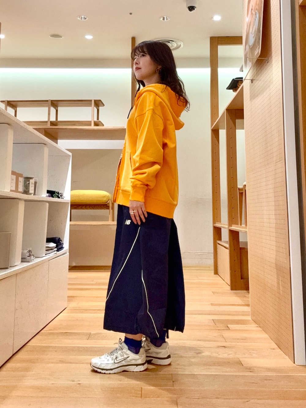 ホワイト系のスニーカー、グレー系のバックパック/リュック、ブルー系のスカートを着用したレディースの春コーディネートの2枚目の写真