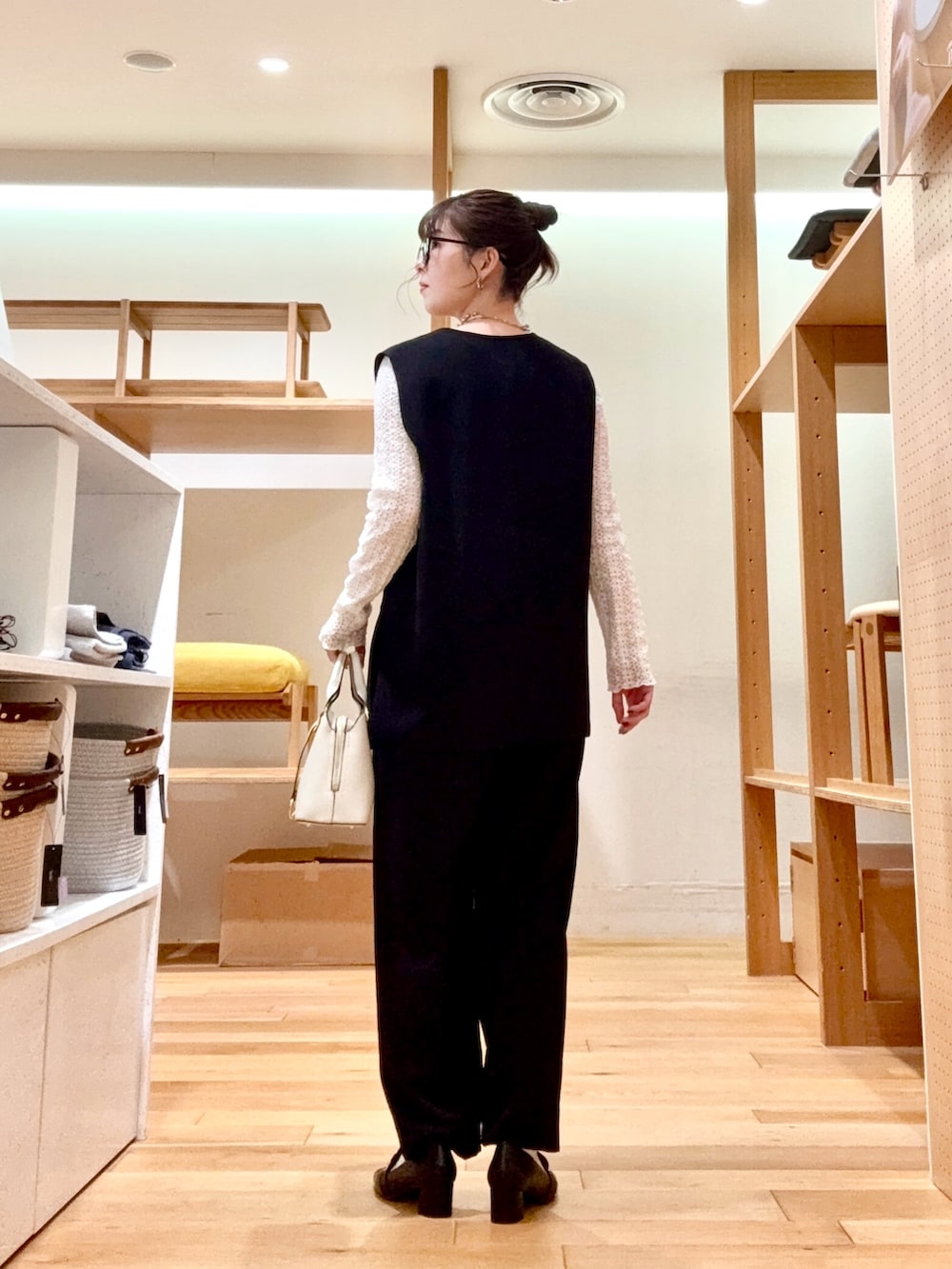 ホワイト系のTシャツ/カットソー、ブラック系のベスト、ブラック系のその他パンツを着用したレディースの冬コーディネートの3枚目の写真