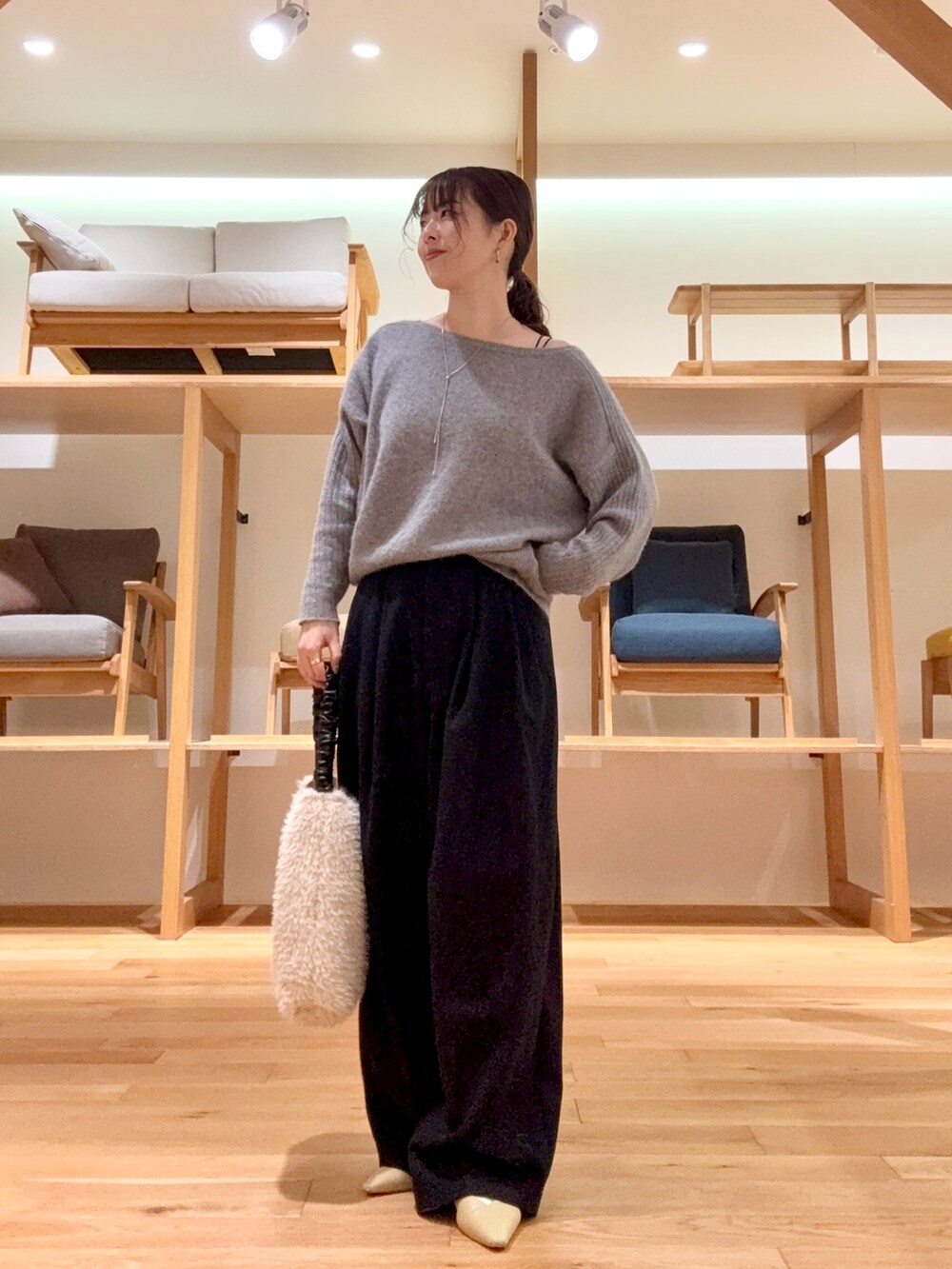 ブラック系のチェスターコート、ブラック系のその他パンツ、グレー系のニット/セーターを着用したレディースの冬コーディネートの2枚目の写真