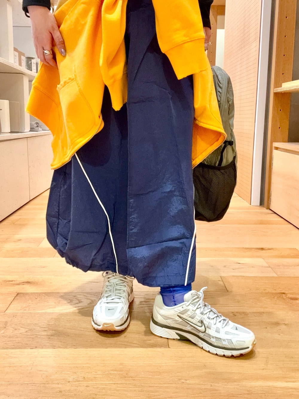 ホワイト系のスニーカー、グレー系のバックパック/リュック、ブルー系のスカートを着用したレディースの春コーディネートの8枚目の写真