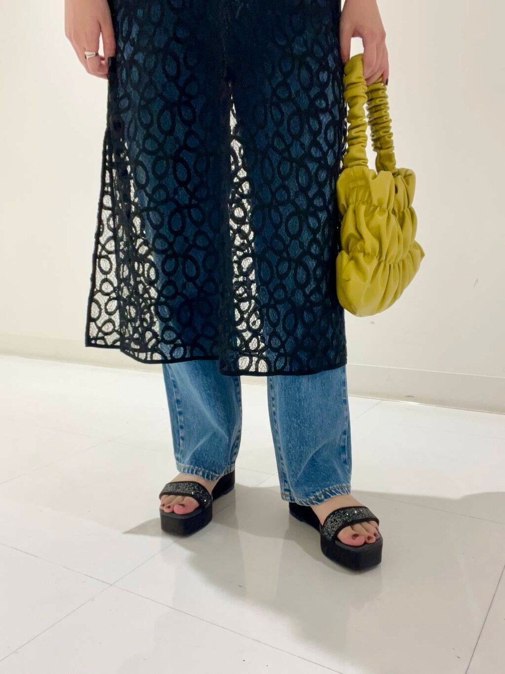 グレー系のTシャツ/カットソー、イエロー系のハンドバッグ、ブラック系のサンダルを着用したレディースの秋コーディネートの4枚目の写真