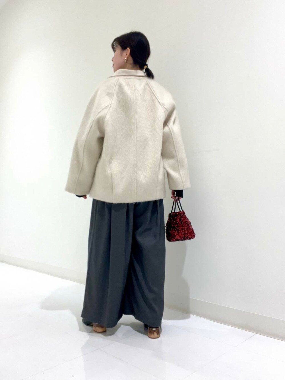 グレー系のその他パンツ、ホワイト系のシャツ/ブラウス、レッド系のショルダーバッグを着用したレディースの冬コーディネートの6枚目の写真