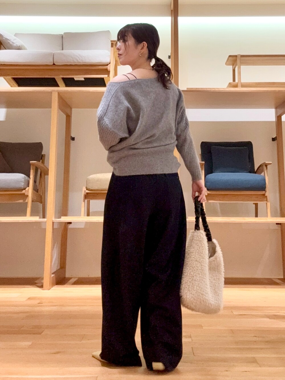 ブラック系のチェスターコート、ブラック系のその他パンツ、グレー系のニット/セーターを着用したレディースの冬コーディネートの8枚目の写真