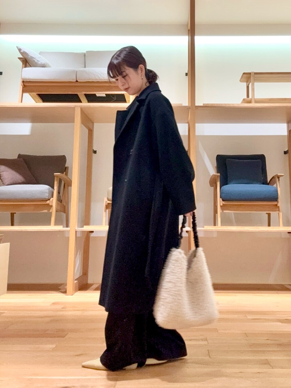 ブラック系のチェスターコート、ブラック系のその他パンツ、グレー系のニット/セーターを着用したレディースの冬コーディネートの5枚目の写真