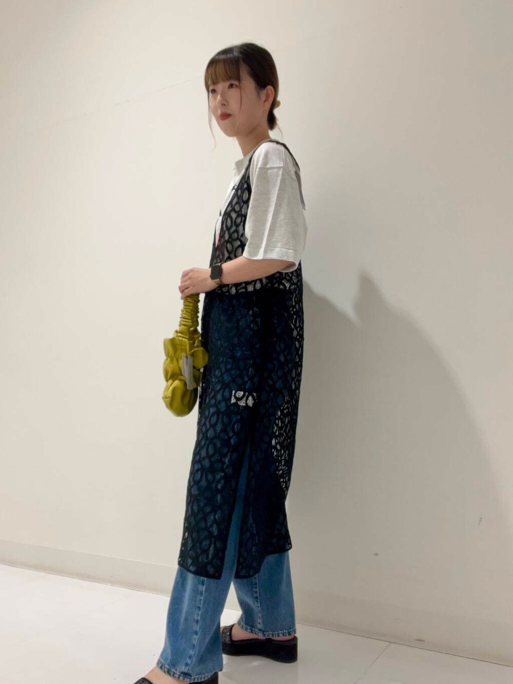 グレー系のTシャツ/カットソー、イエロー系のハンドバッグ、ブラック系のサンダルを着用したレディースの秋コーディネートの2枚目の写真