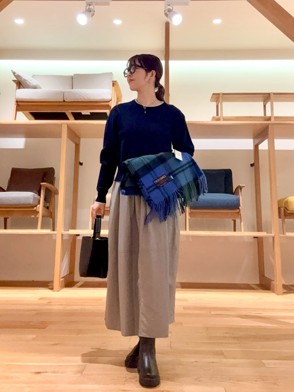 ブラック系のピーコート、ブラック系のハンドバッグ、ブルー系のニット/セーターを着用したレディースの冬コーディネートの5枚目の写真