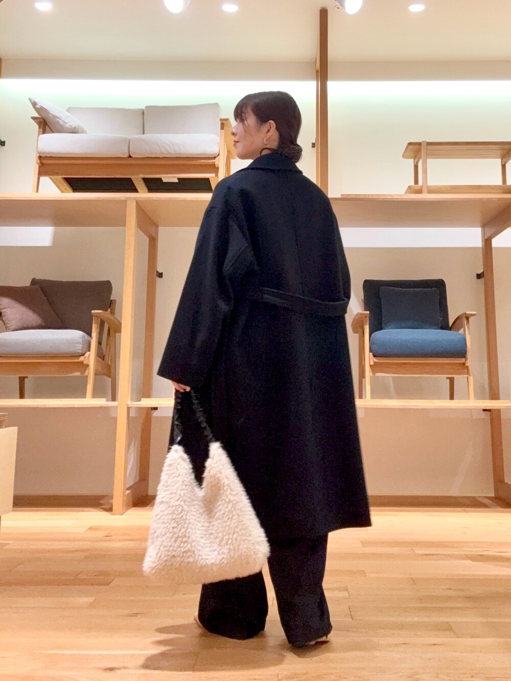 ブラック系のチェスターコート、ブラック系のその他パンツ、グレー系のニット/セーターを着用したレディースの冬コーディネートの6枚目の写真