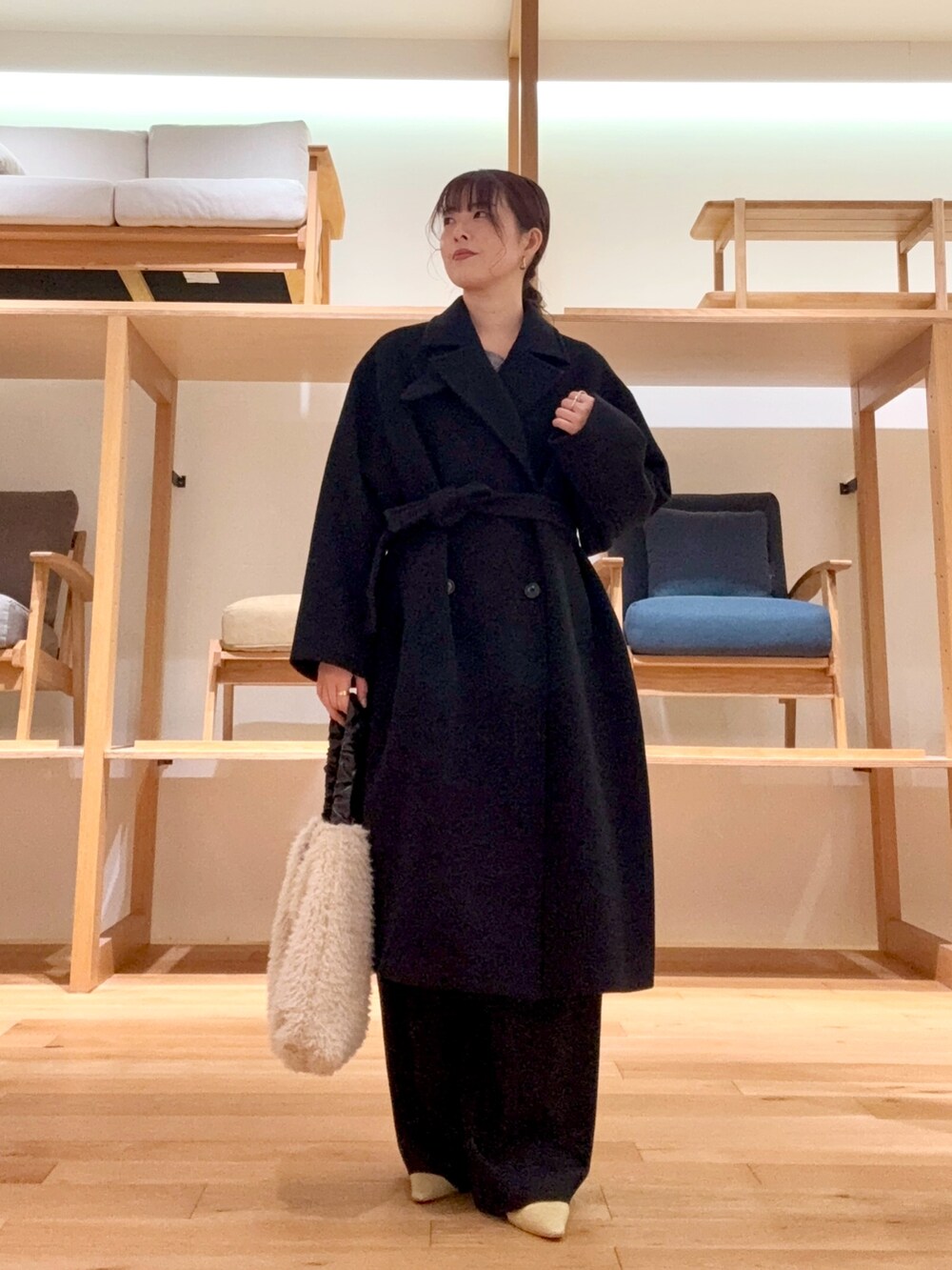 ブラック系のチェスターコート、ブラック系のその他パンツ、グレー系のニット/セーターを着用したレディースの冬コーディネートの4枚目の写真