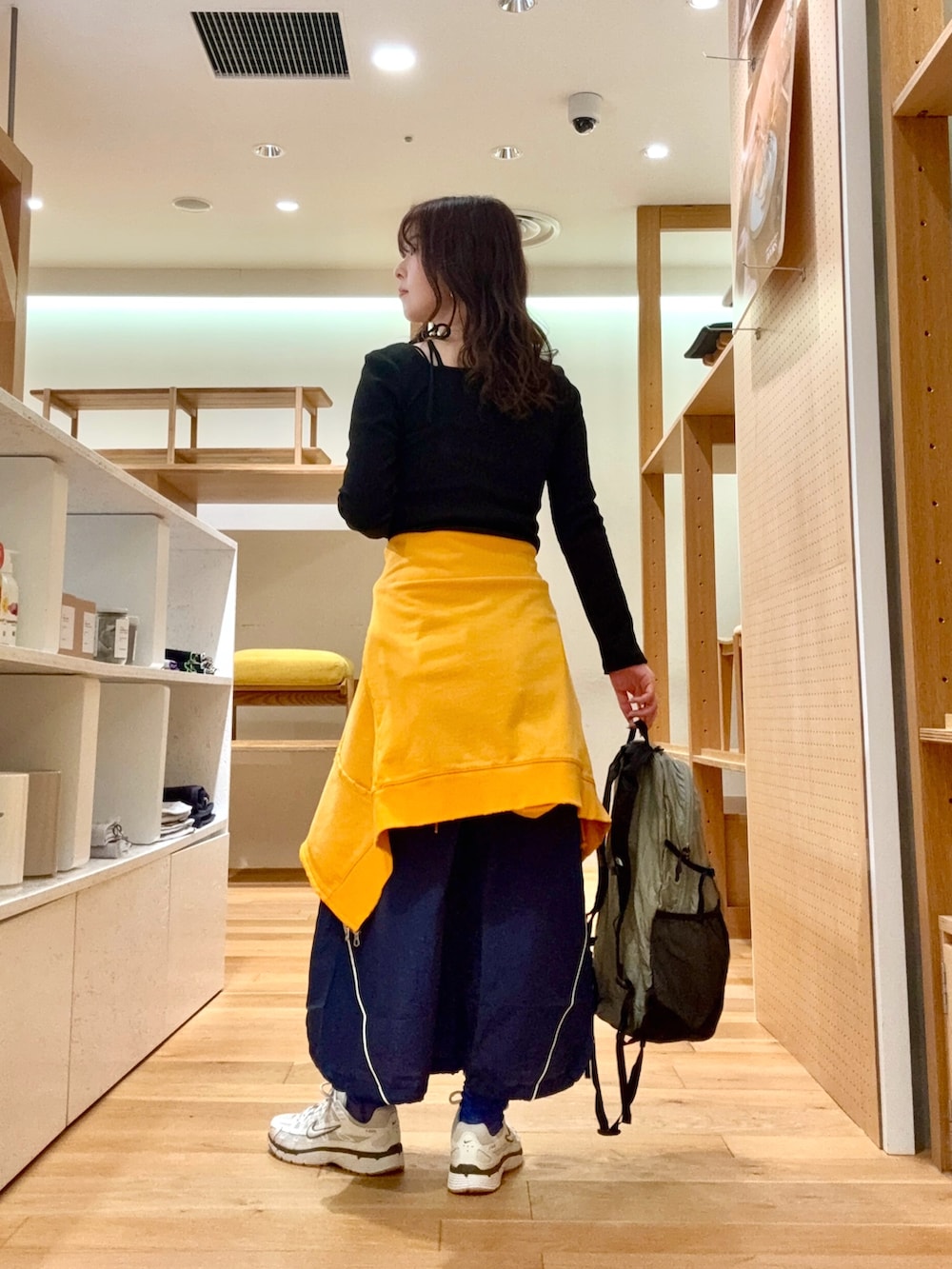 ホワイト系のスニーカー、グレー系のバックパック/リュック、ブルー系のスカートを着用したレディースの春コーディネートの6枚目の写真