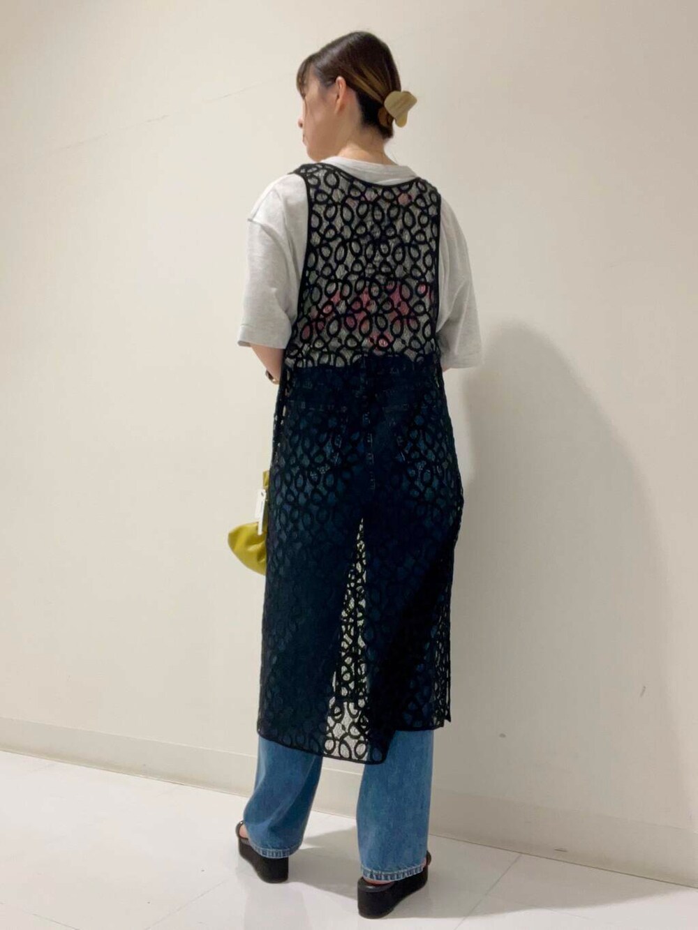 グレー系のTシャツ/カットソー、イエロー系のハンドバッグ、ブラック系のサンダルを着用したレディースの秋コーディネートの3枚目の写真