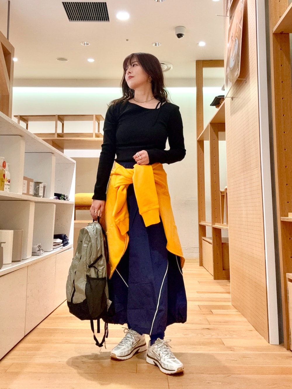 ホワイト系のスニーカー、グレー系のバックパック/リュック、ブルー系のスカートを着用したレディースの春コーディネートの4枚目の写真