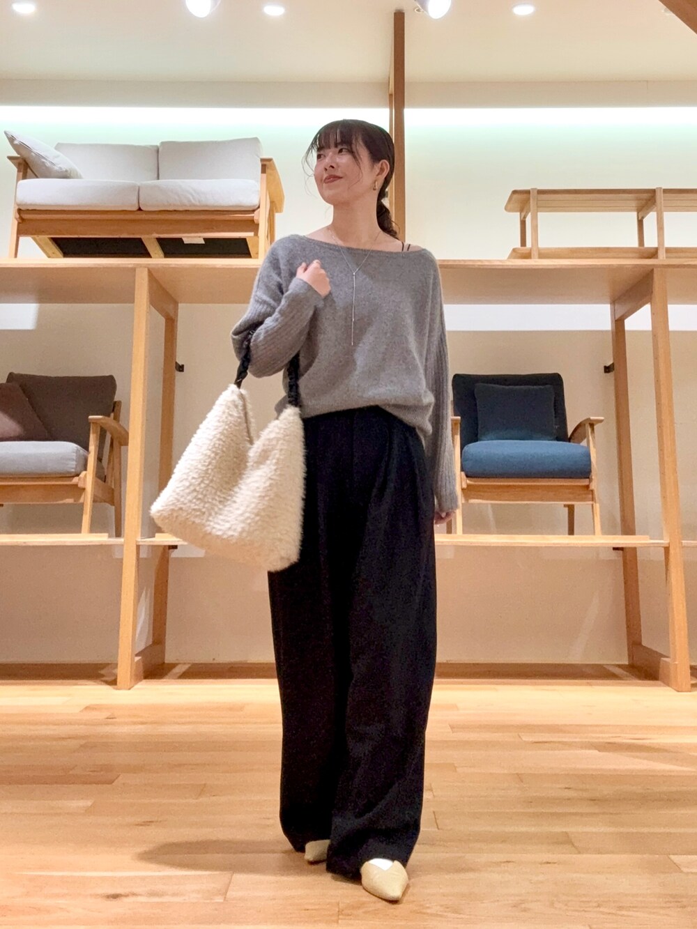ブラック系のチェスターコート、ブラック系のその他パンツ、グレー系のニット/セーターを着用したレディースの冬コーディネートの3枚目の写真