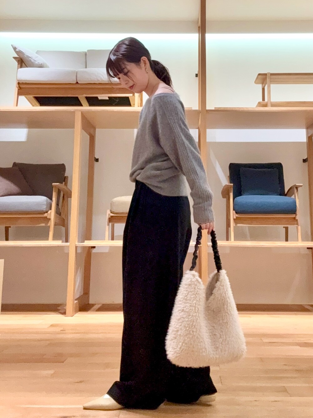 ブラック系のチェスターコート、ブラック系のその他パンツ、グレー系のニット/セーターを着用したレディースの冬コーディネートの7枚目の写真