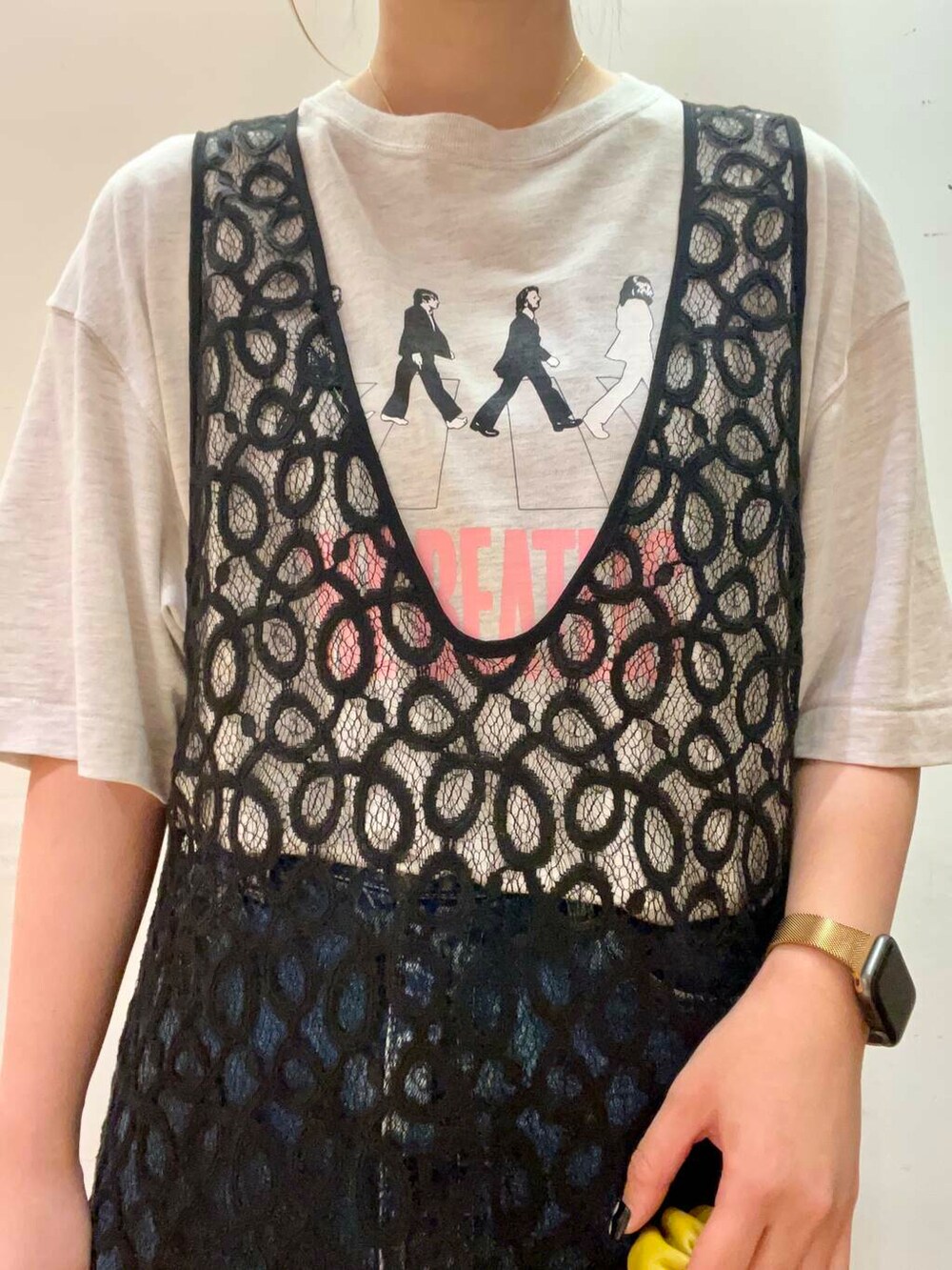 グレー系のTシャツ/カットソー、イエロー系のハンドバッグ、ブラック系のサンダルを着用したレディースの秋コーディネートの5枚目の写真